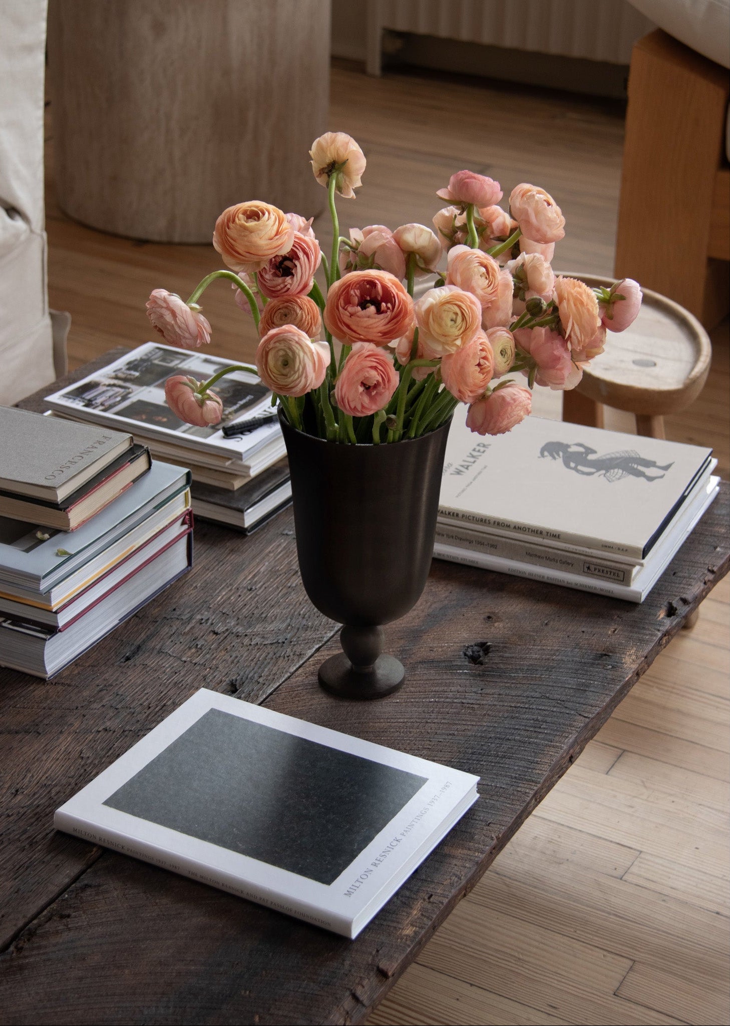 Floral arrangement in a vase on a wooden table with books